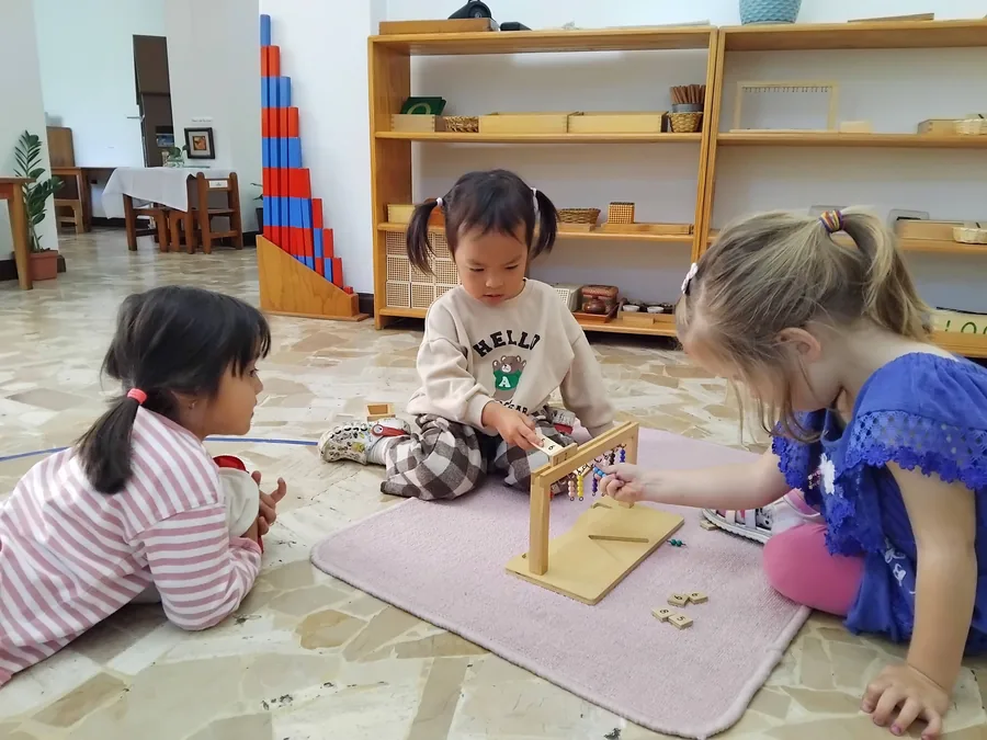 Preschool children working together with the counting frame